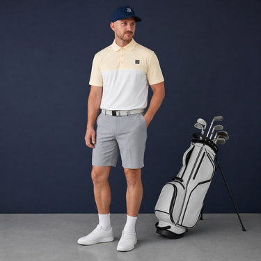 HARG Comfort Fit golf polo shirt in lemon yellow and chalk white colorblock, made from breathable performance fabric.
